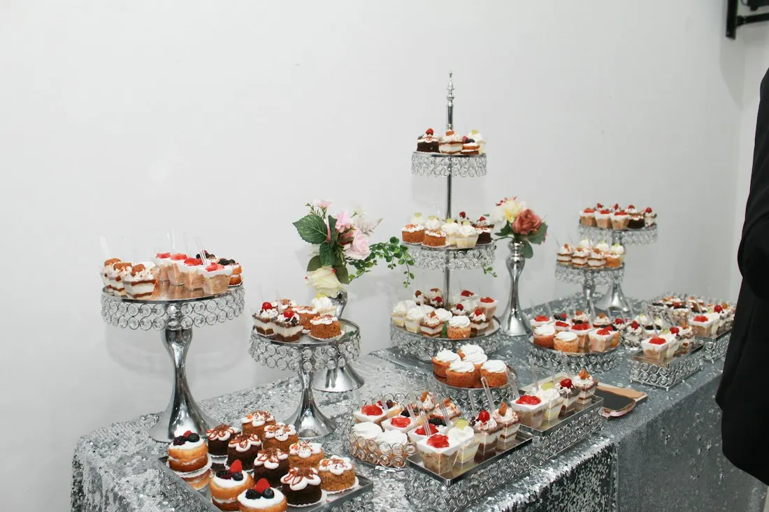 Mesa de doces com cupcakes em bandejas de vidro