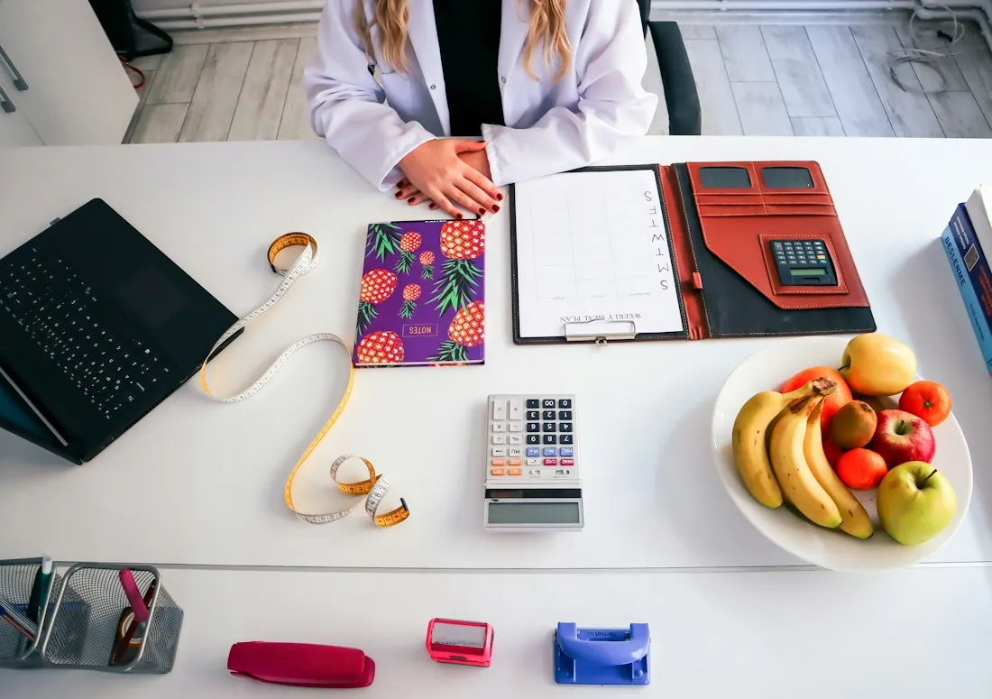 Mesa do consultório com prancheta, frutas e fita métrica