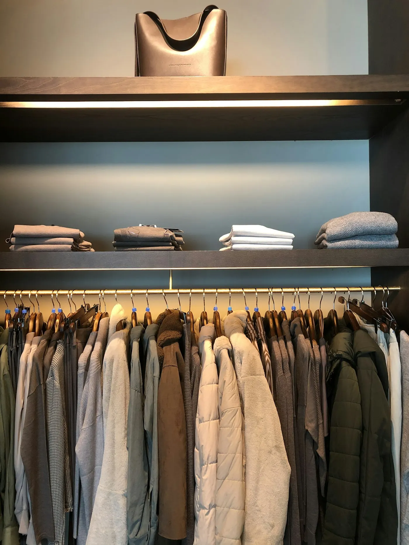 Armário com roupas dobradas por categoria e cabides alinhados, depois da organização