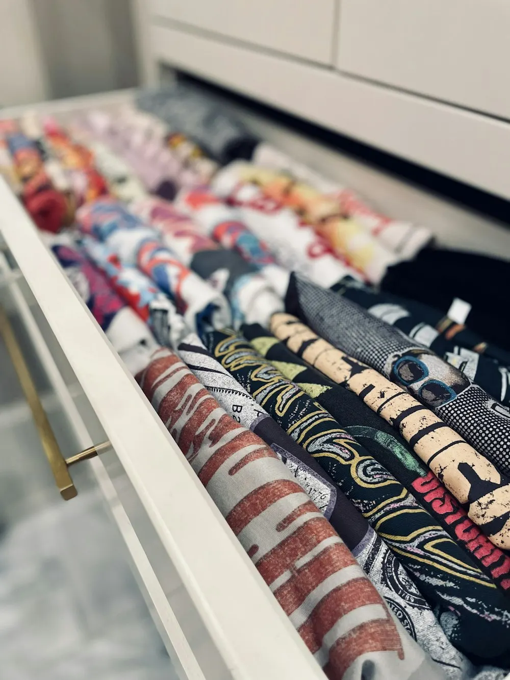 Gaveta com camisetas enroladas lado a lado